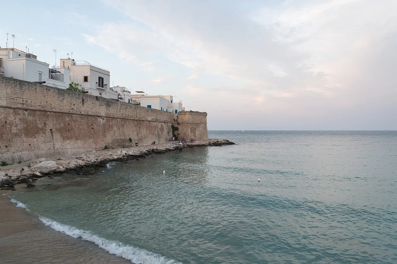 Cala Porta Vecchia below Monopoli's old-town walls on a summer afternoon